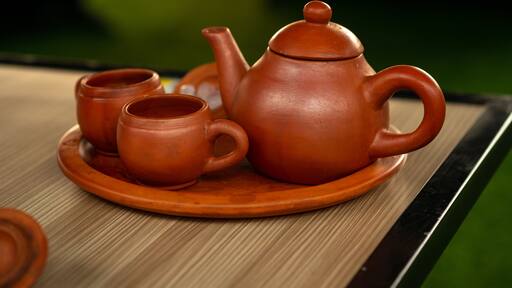 Traditional clay teapot and cups (Teh Poci) from Central Java on a tray. A rustic earthenware tea set, typical of Tegal culture, serving hot tea against a blurred background.