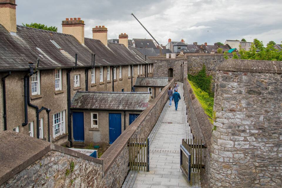 A narrow street flanked by terraced houses with stone walls and chimneys.