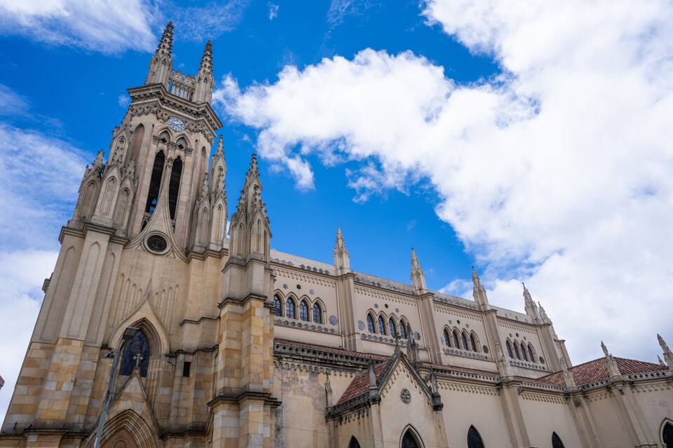 Una gran catedral amb espirals ornamentades i finestres apuntades sota un cel mig ennuvolat.