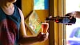 Iemand giet bier in een glas.