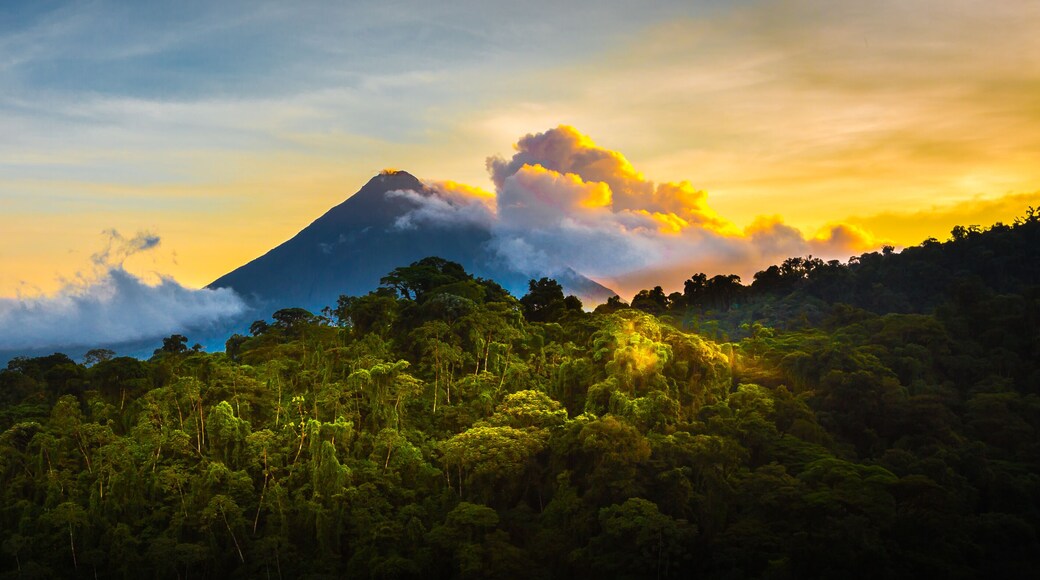 Arenal Volcano at Sunrise...A rare sight at the perfect 15 second window to capture sunrise in all of it's glory. Light glistens off the clouds and the mountain and the jungle.