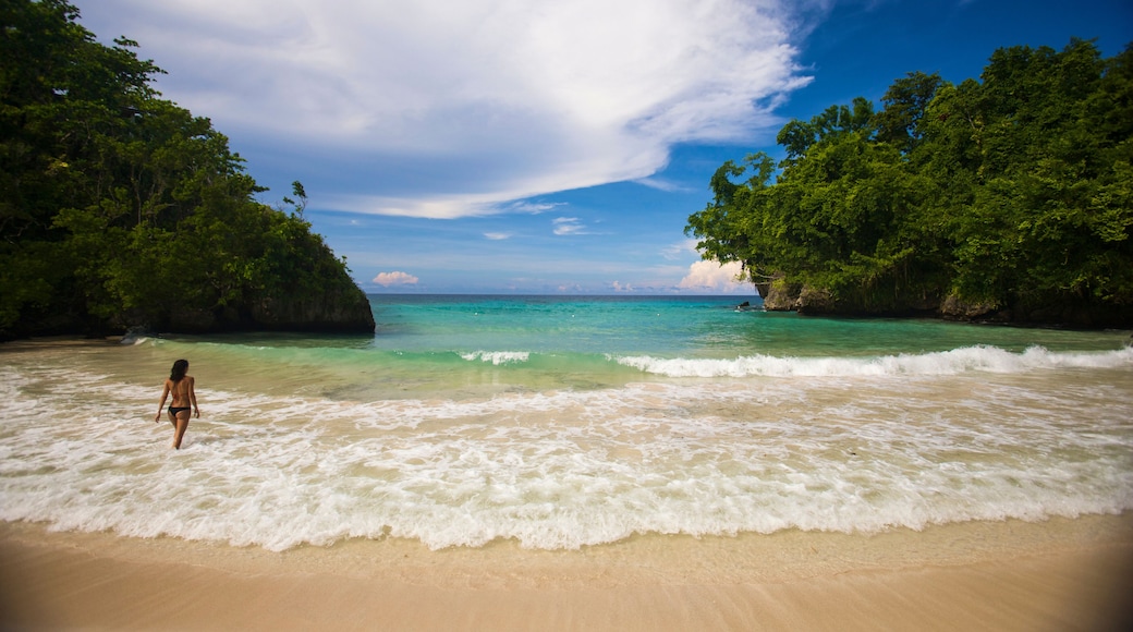Woman wades in the surf at Frenchman's Cove in Tobago; Port Antonio, Jamaica