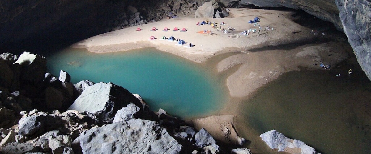 Una grotta con una spiaggia sabbiosa e acqua turchese.