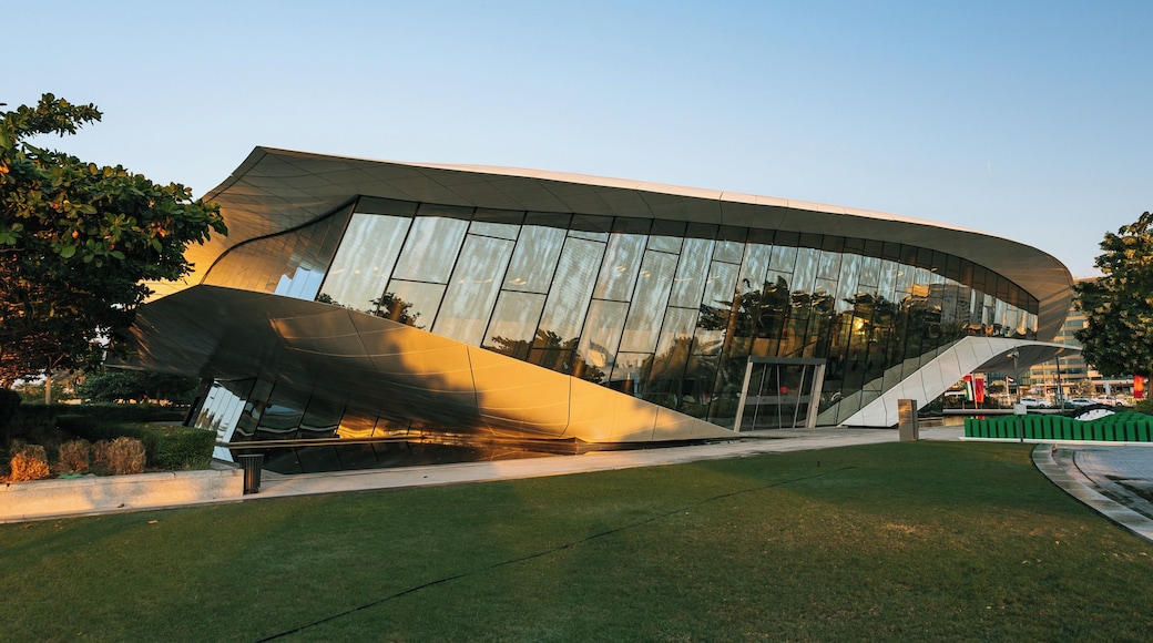 A modern architectural building with a curved roof and reflective glass facade.