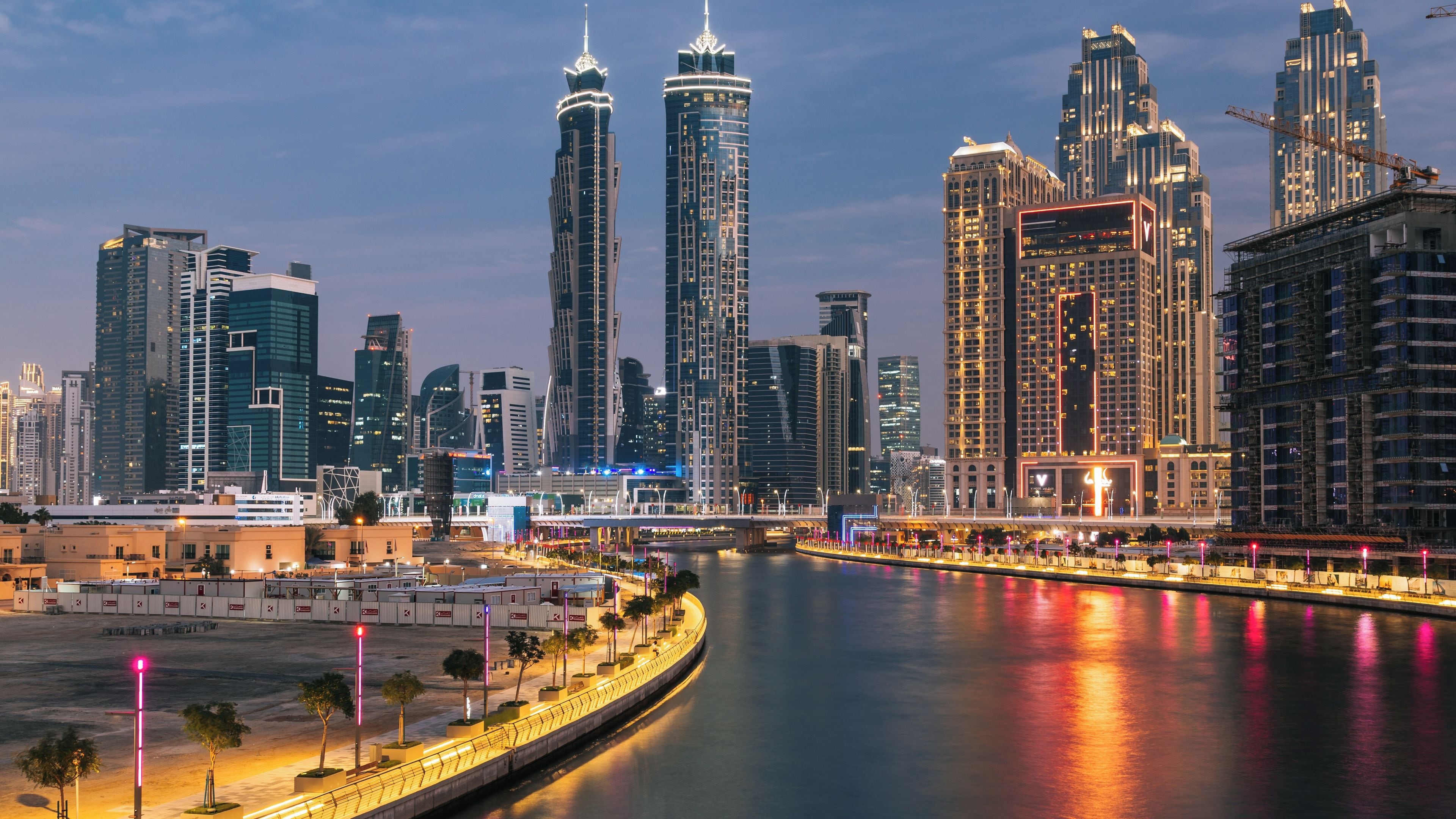 A city skyline with modern skyscrapers, a river, and a bridge.