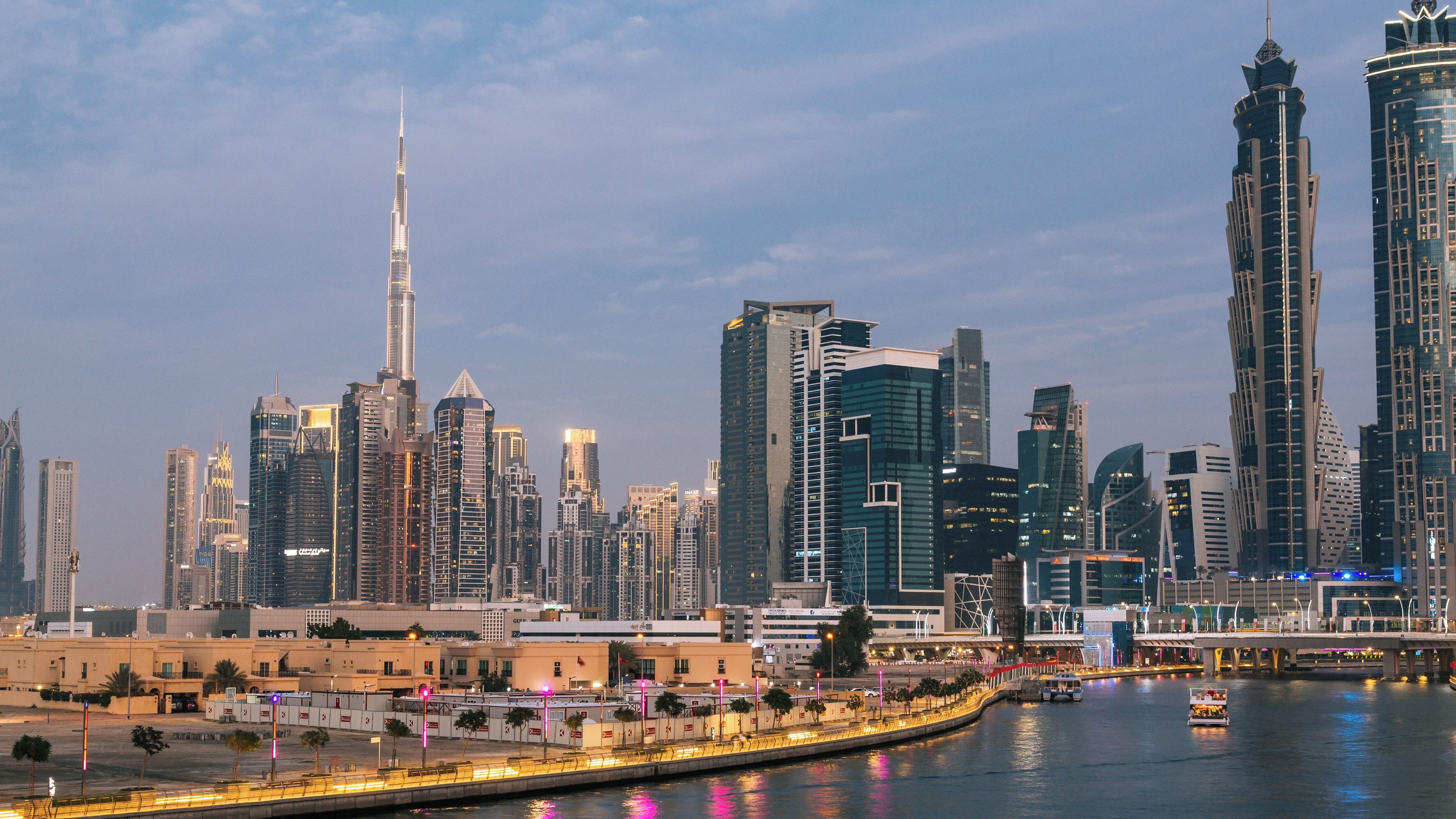 Una skyline cittadina con grattacieli moderni, un fiume e un ponte.