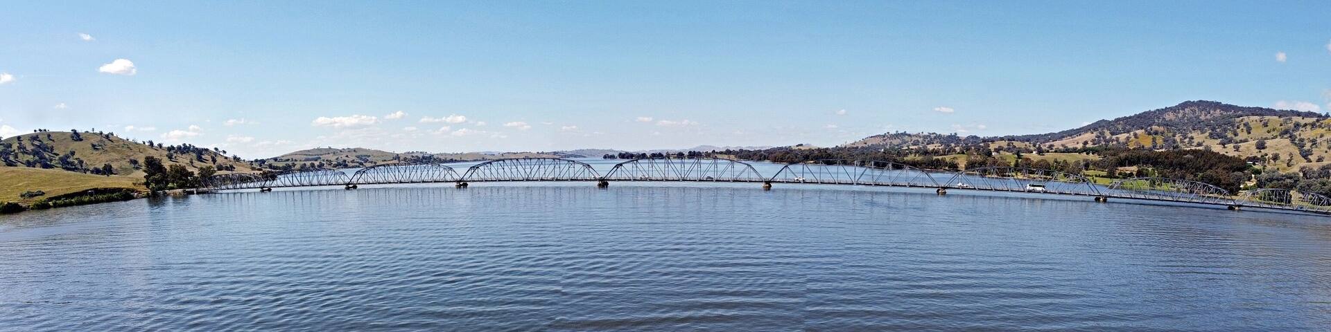 The panoramic view of Bethanga Bridge is a steel truss road bridge that carries the Riverina Highway across Lake Hume, an artificial lake on the Murray River in Australia. Image by drone flying.