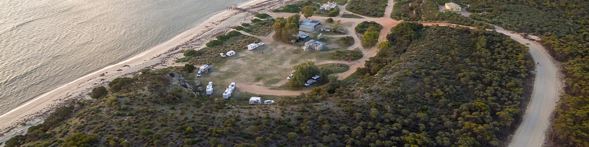 Aerial view of caravans and four wheel drive vehicles at a free camp next to the seaside in Australia