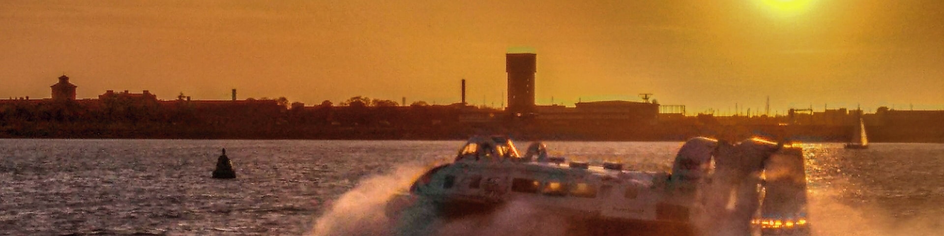 Regular hovercraft passenger service from Portsmouth to Ryde on the Isle of Wight. Sun setting over the former Haslar Royal Navy hospital in Gosport.