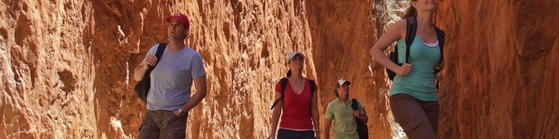 Standley Chasm featuring a gorge or canyon and hiking or walking as well as a small group of people