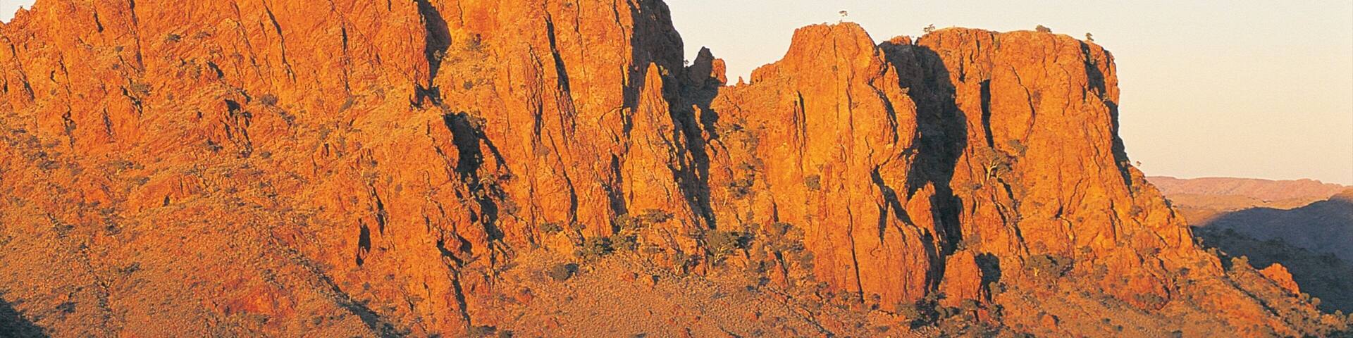 A large, rugged mountain with steep cliffs and sparse vegetation.