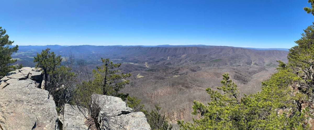 A mountainous landscape with rocky outcrops and scattered trees.