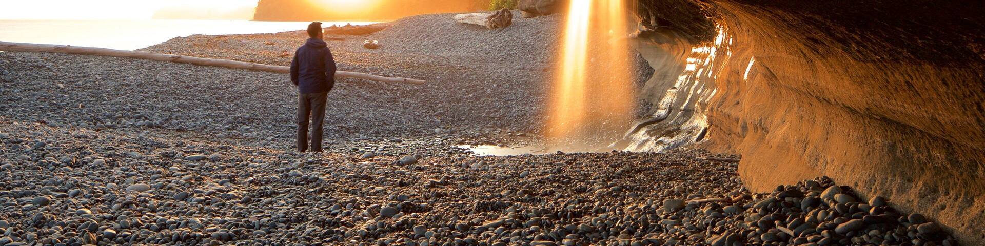 Sooke featuring a sunset and a pebble beach as well as an individual male