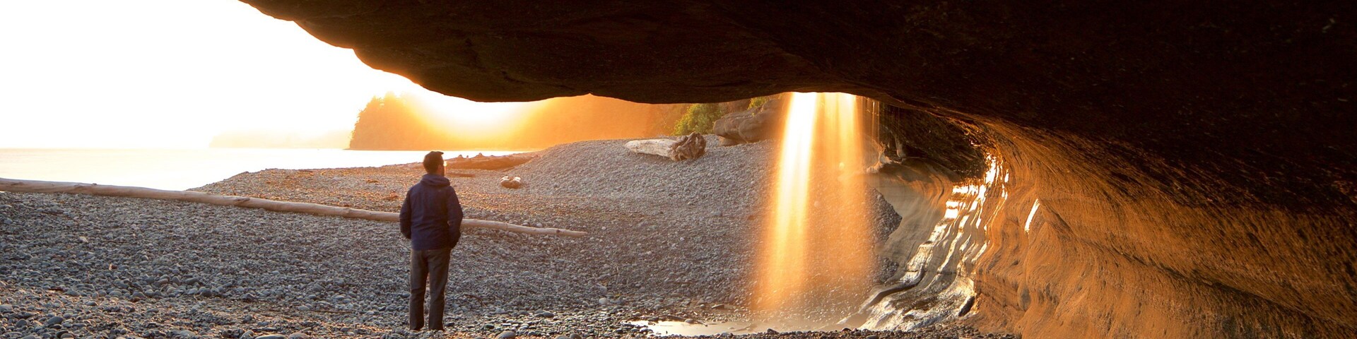 Sooke mostrando una playa de piedras y un atardecer y también un hombre