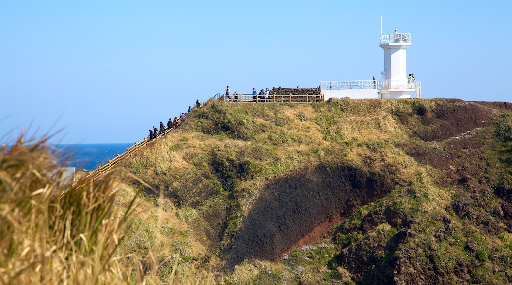 Jeju Island featuring landscape views, hiking or walking and a lighthouse