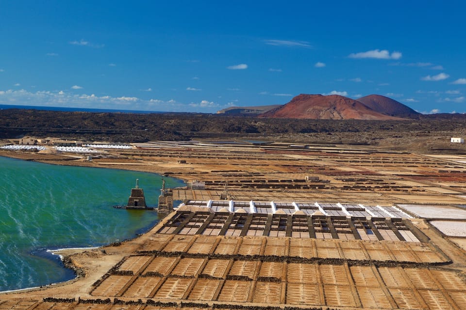 Uma planície salina com campos em terraços e um corpo d'água.