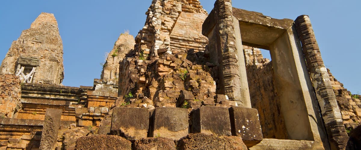 Ancient stone ruins with a large, intact temple structure and a smaller, deteriorated tower.