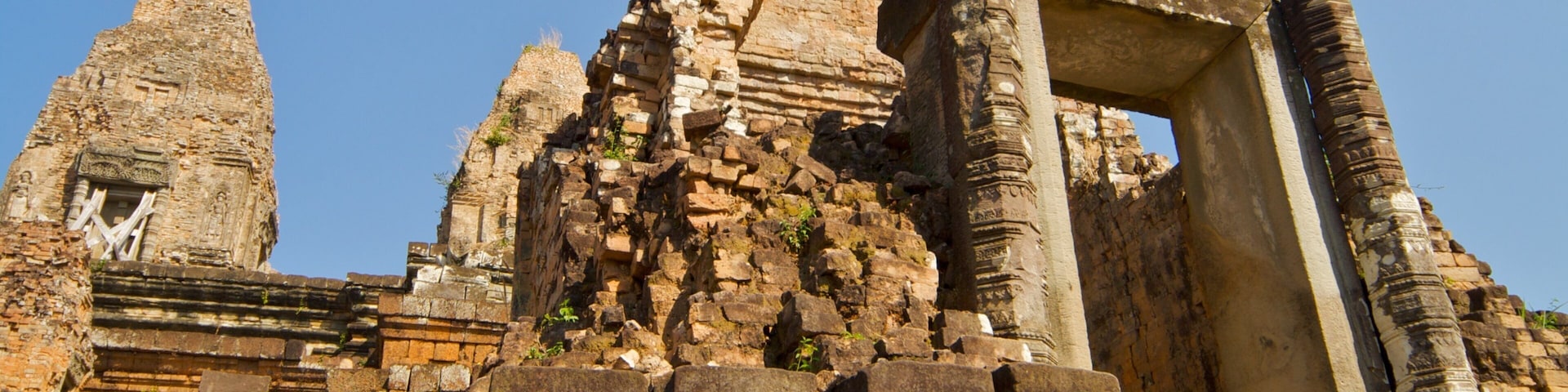 Ancient stone ruins with a large, intact temple structure and a smaller, deteriorated tower.