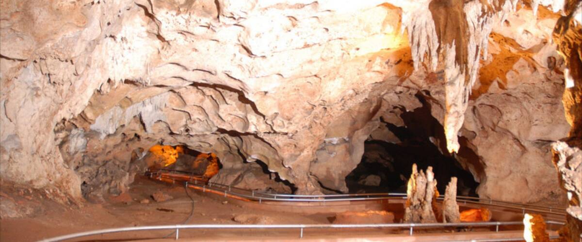 A cave with a metal walkway and stalactites.