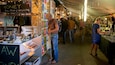 Un marché animé où l’on trouve des étals vendant du miel et d’autres produits alimentaires.