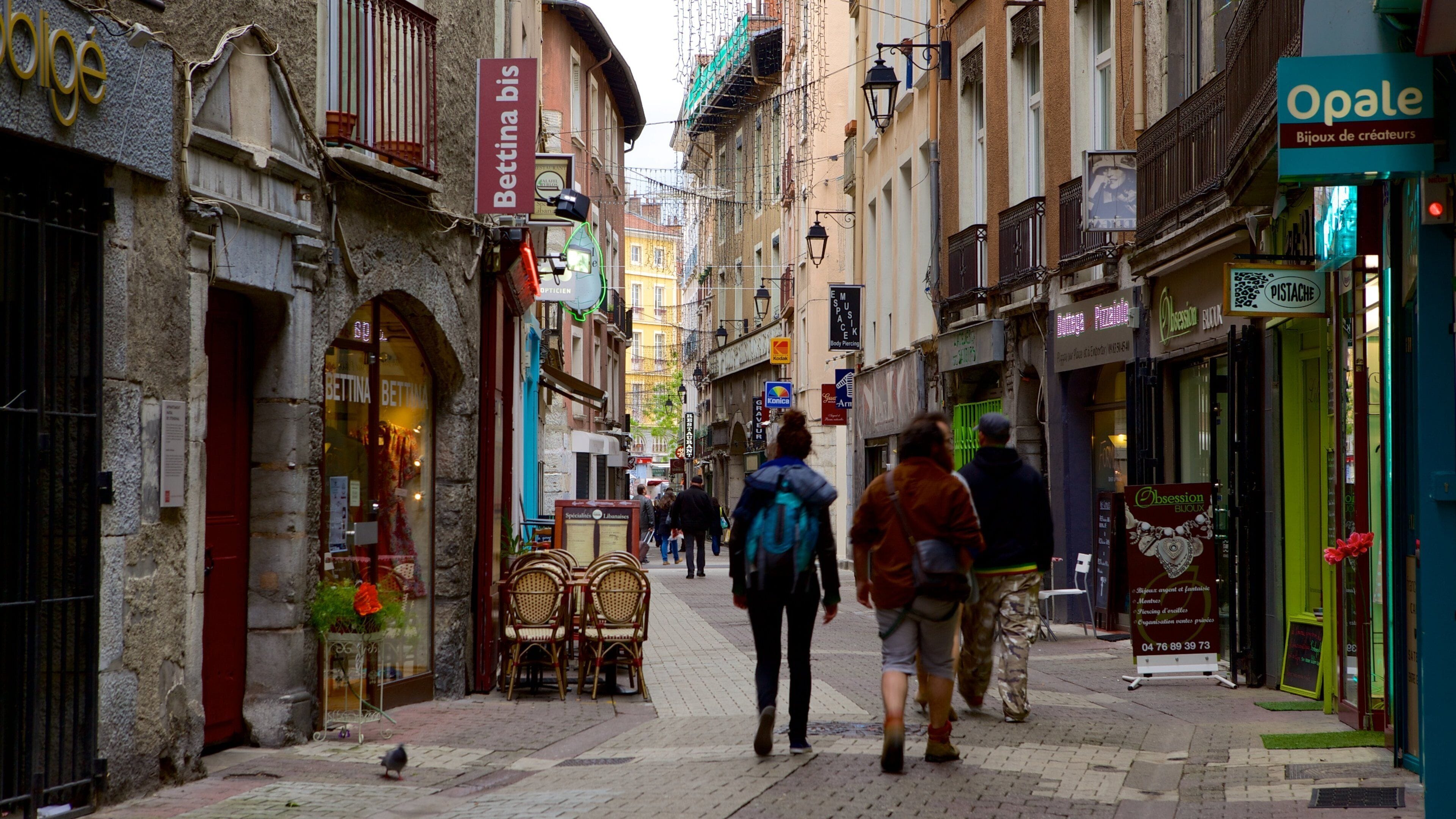 A narrow street lined with shops and cafes, including a visible sign for 'Betina bis' and 'Opale Bijoux de créateurs'.