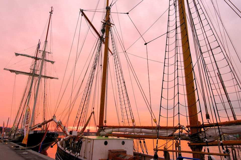 Diverses naus altes amarrades al port durant el capvespre.