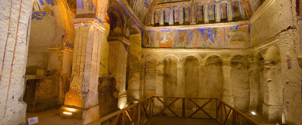 An ancient church interior with arched ceilings, columns, and a wooden railing.