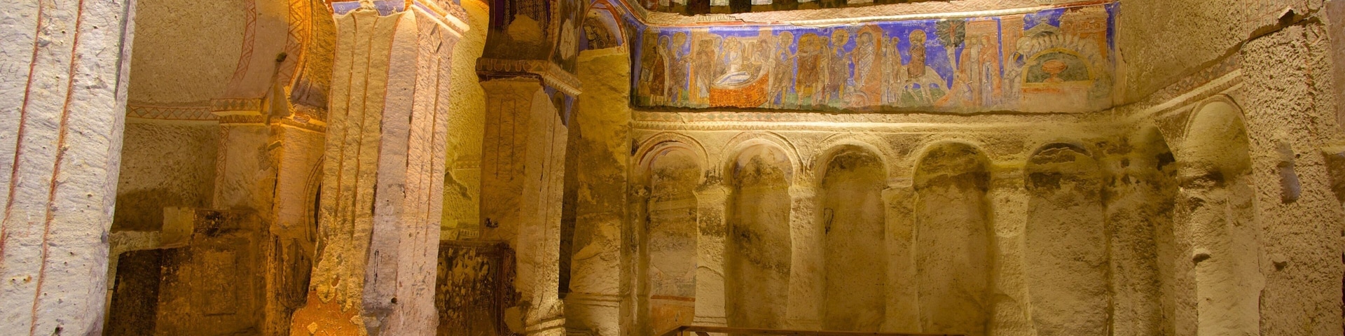 An ancient church interior with arched ceilings, columns, and a wooden railing.