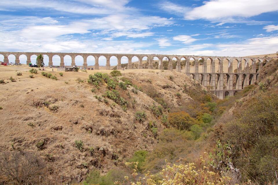 A long viaduct with multiple arches spanning a dry, hilly landscape.