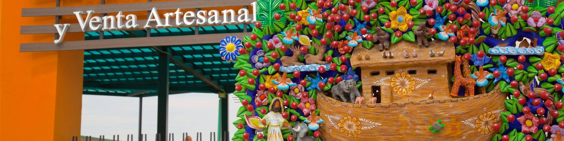 A colorful display with a wooden boat, flowers, and a figure of a person.