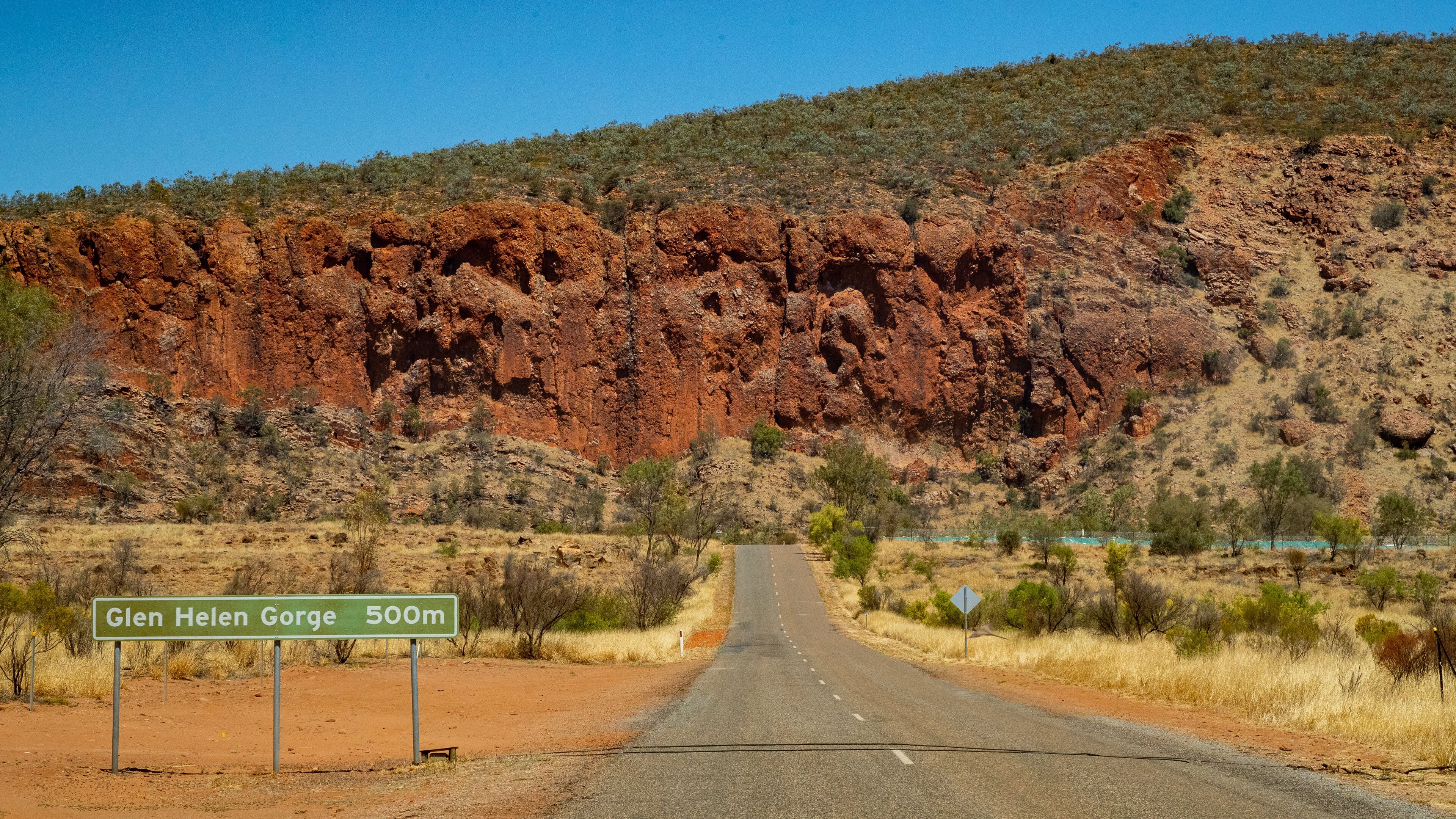 Glen Helen Gorge featuring desert views, tranquil scenes and signage