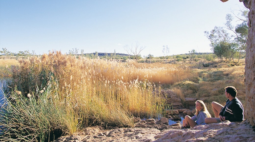 Alice Springs que incluye escenas tranquilas y un lago o abrevadero y también una pareja