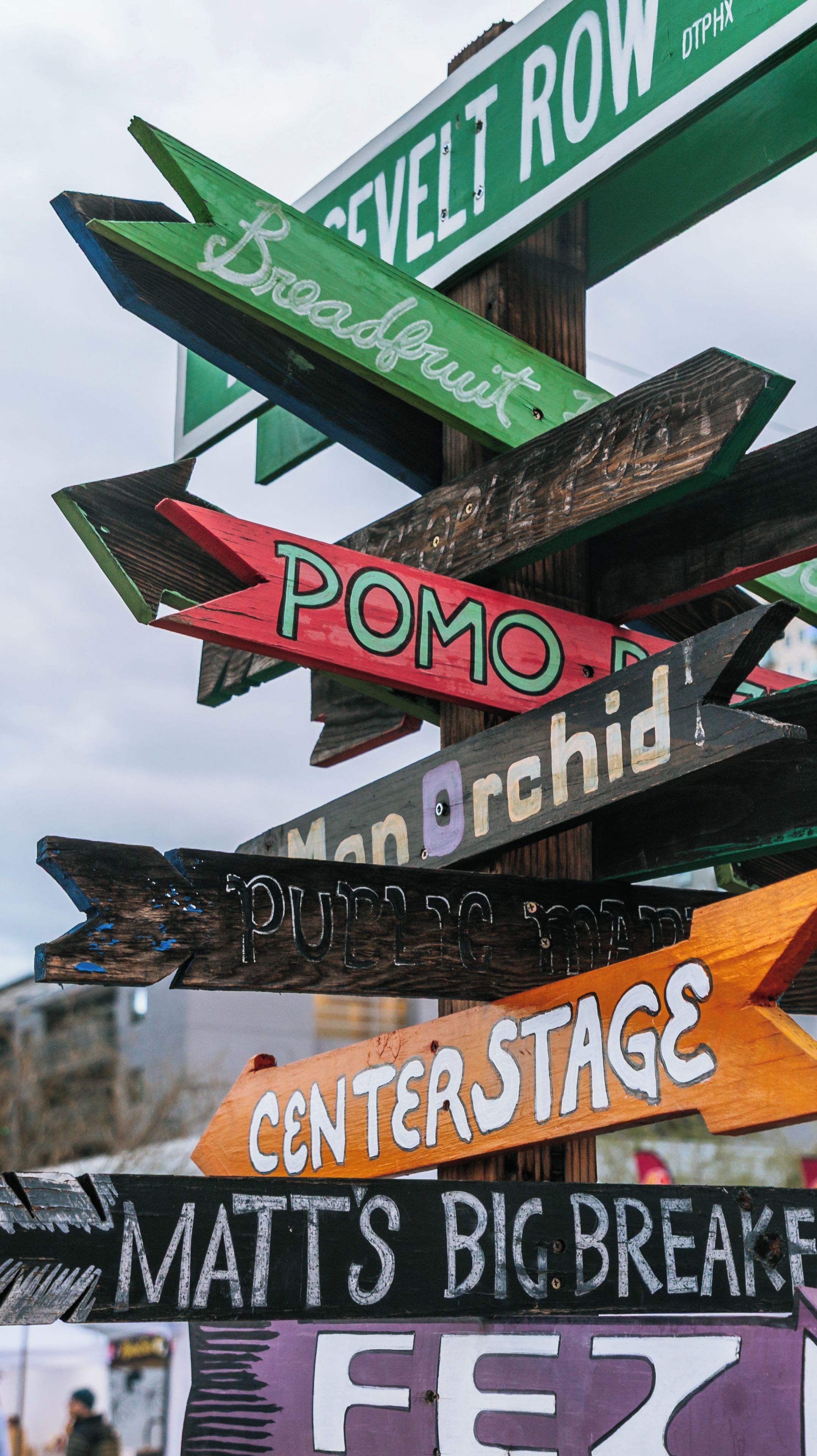 A collection of colorful directional signs with names like 'SEVELT ROW,' 'Broadview,' 'POMO,' 'Manor,' 'PUTZ,' 'CENTER STAGE,' 'MATTS BIG BREAK,' and 'FEL.'