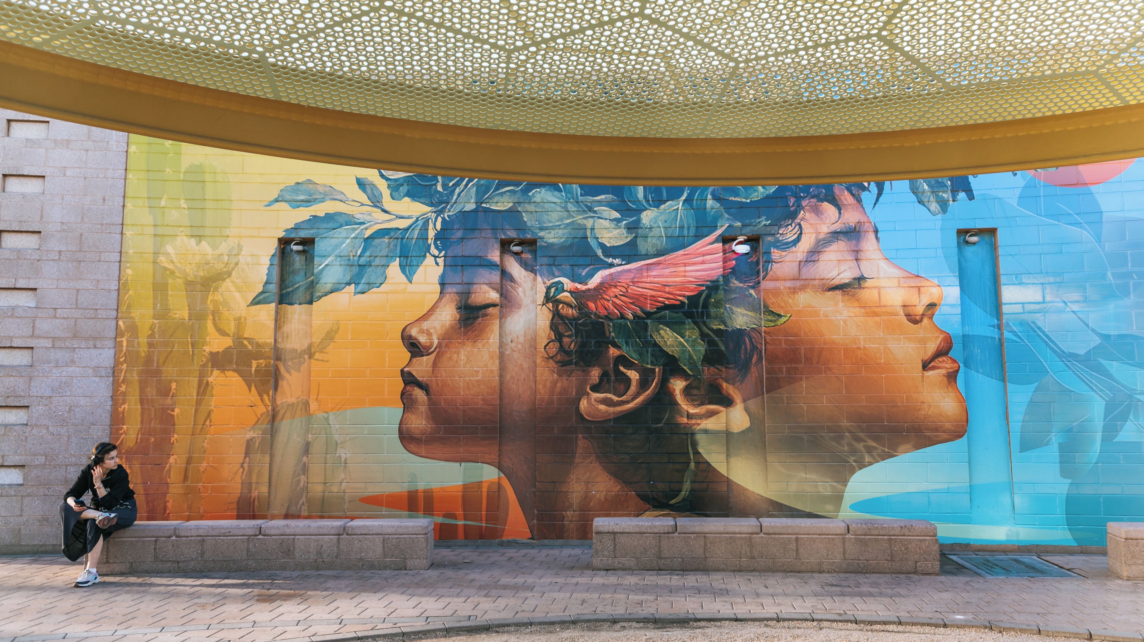 A mural with a woman's face and a bird on a building.