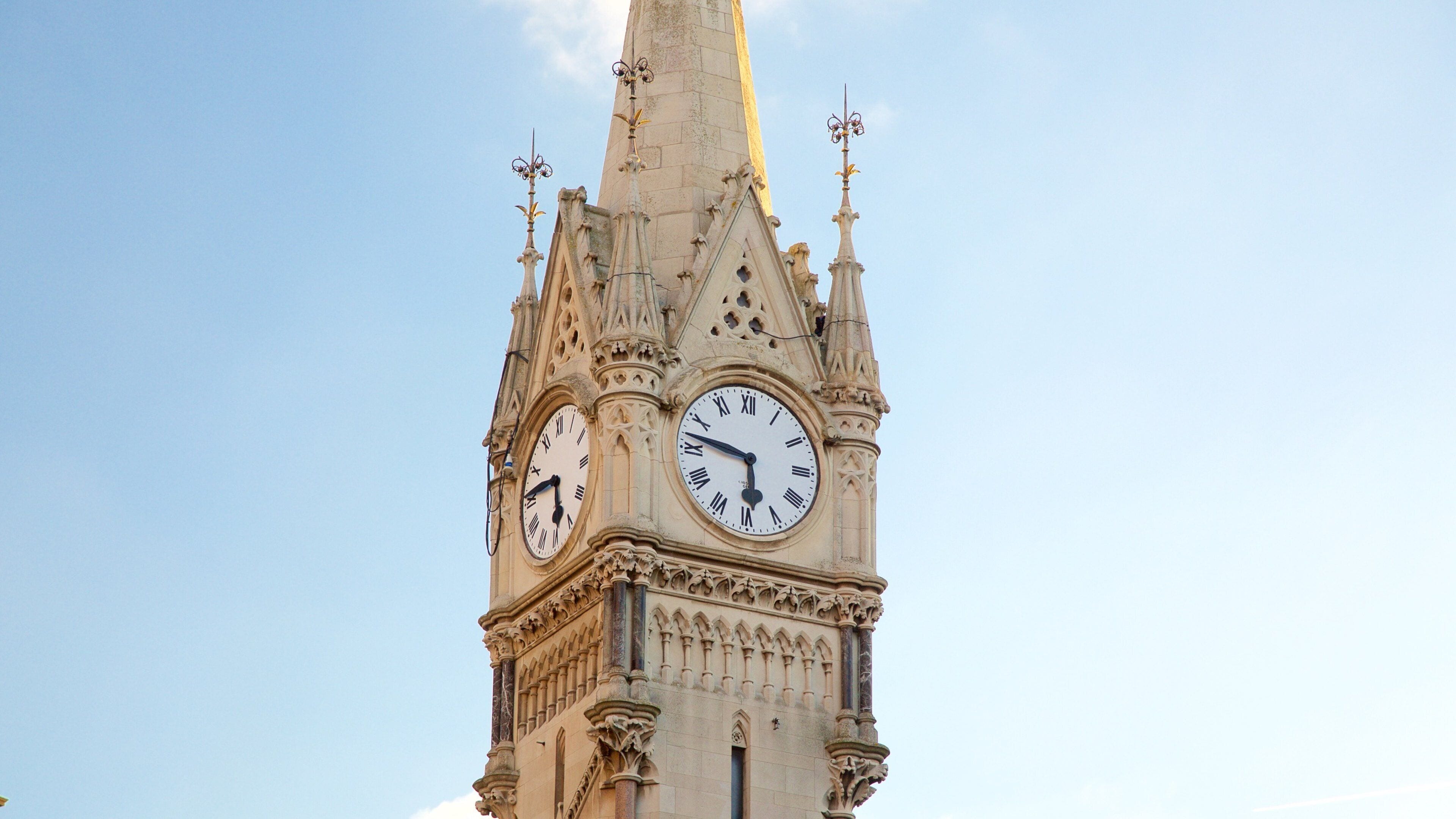 A tall clock tower with intricate architectural details and a pointed spire.