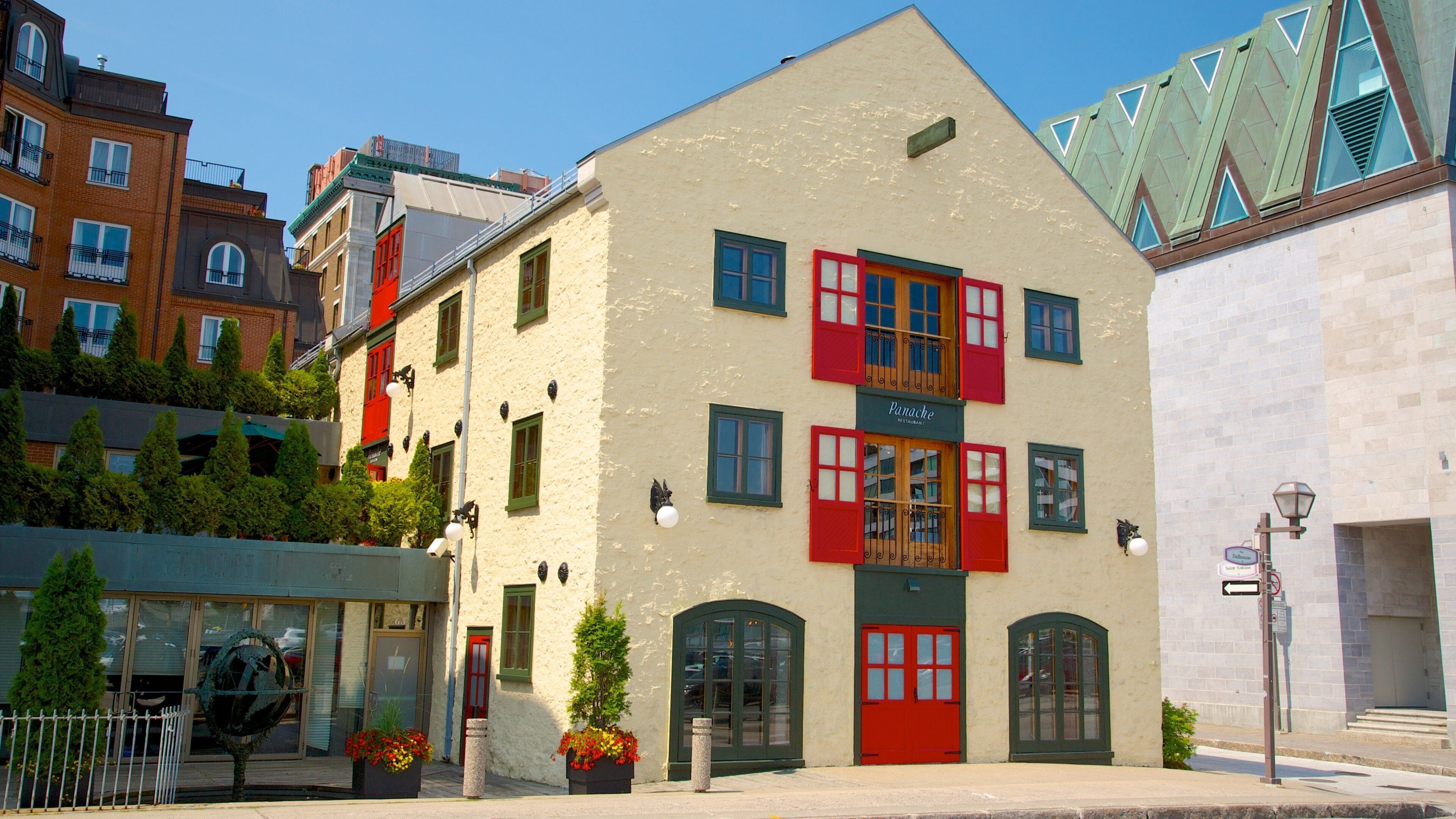 Un bâtiment avec des volets rouges et une enseigne sur laquelle on peut lire « Restaurant Panache ».