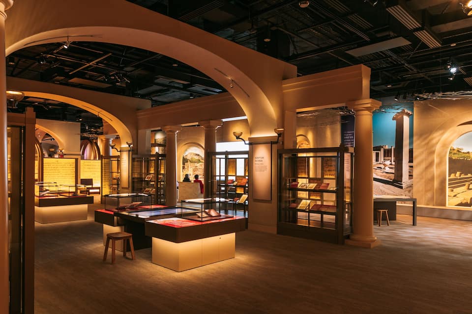 Een interieur tentoonstellingsruimte met gewelfde plafonds, vitrines en informatieborden.