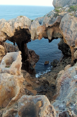 I then lay awake for the rest of the night, awaiting a sunrise that also turned out to be mediocre so I thought I’d check out the cliffs and, how easy did that turn out to be.
Around the lighthouse area is the Pupulong Walk Trail and it skirts the cliffs, offering views of landscapes that are perfectly described by the adjective “bizarre”.
Undercuts with abstract natural designs and caves carved in inconceivable shapes are there for the viewing.
The walk, from Tookalup, where there are toilets, to Point D’Entrecasteaux is only 1.3 kilometres long and it’s on freshly laid bitumen. There are many warnings about not risking the cliff edges but past trails indicate that some have ignored them.
Other older established walks on a gravel base lead off in other directions but I chose not to be diverted this time. Instead, I opted for nearby Salmon Beach where the road sign said “Not suitable for caravans and buses”.
The way in however, was newly sealed road and easy, though curvy, driving. It’s the carpark where there’s a problem because the turning circle would definitely make life difficult if you were towing something.
It’s from here that you take the short stroll across the dunes to this pristine beach.
This is the sort of place I can tarry for hours, feeling the soft grains squeeze up between my toes as I stroll along white sands towards the dominant ramparts of headlands to the west.
You feel like you want to walk forever, past occasional sandstone outcrops while the offshore breeze stands up the crystal clear waters before the swell collapses in a foamy white display near the shore.
Beside you the grass of the dunes is ruffled by the wind and the occasional grain of sand rolls down off the top. The only other people are an odd fisherman or two and they are only too happy to have a chat.
Western Australia offers many such experiences like this, may I recommend you go out and get yourself one.
#Nature