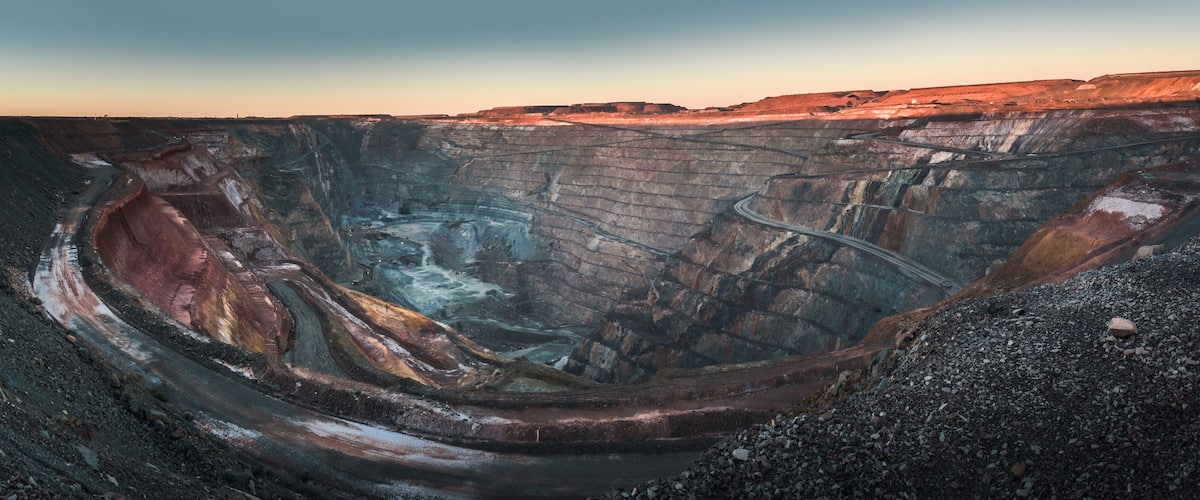 A large open-pit mine with steep walls and a winding road.