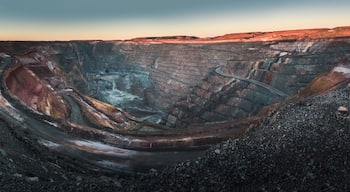 Une vaste mine à ciel ouvert, aux parois abruptes et à laquelle on accède par un chemin sinueux.