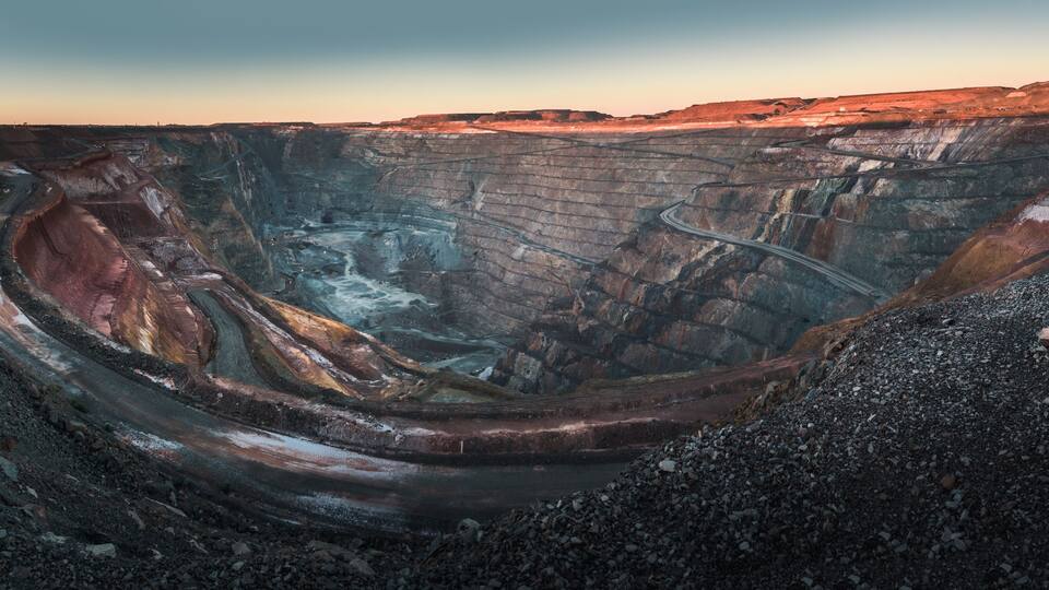 A large open-pit mine with steep walls and a winding road.