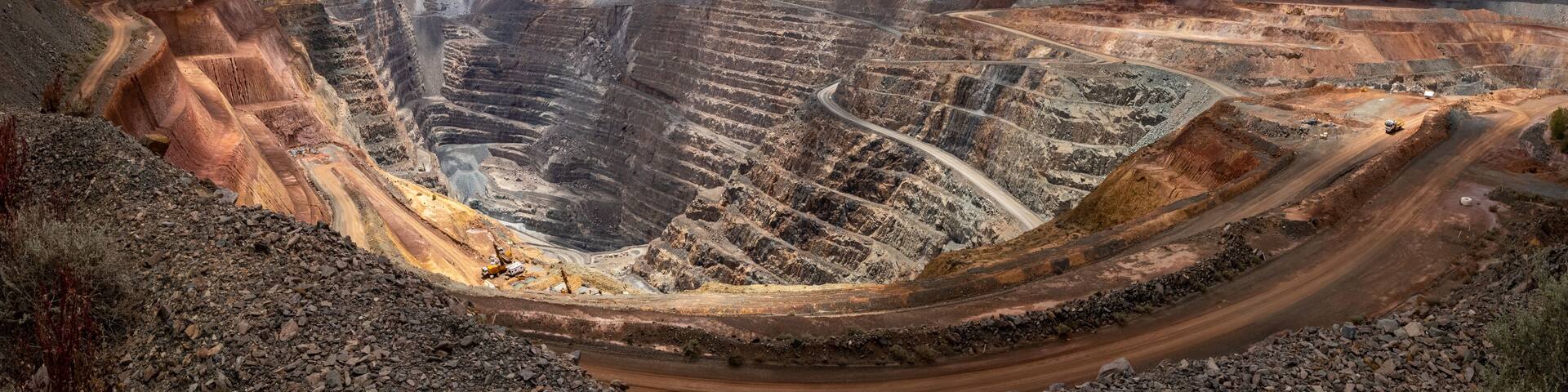 A large open-pit mine with winding roads and heavy machinery.
