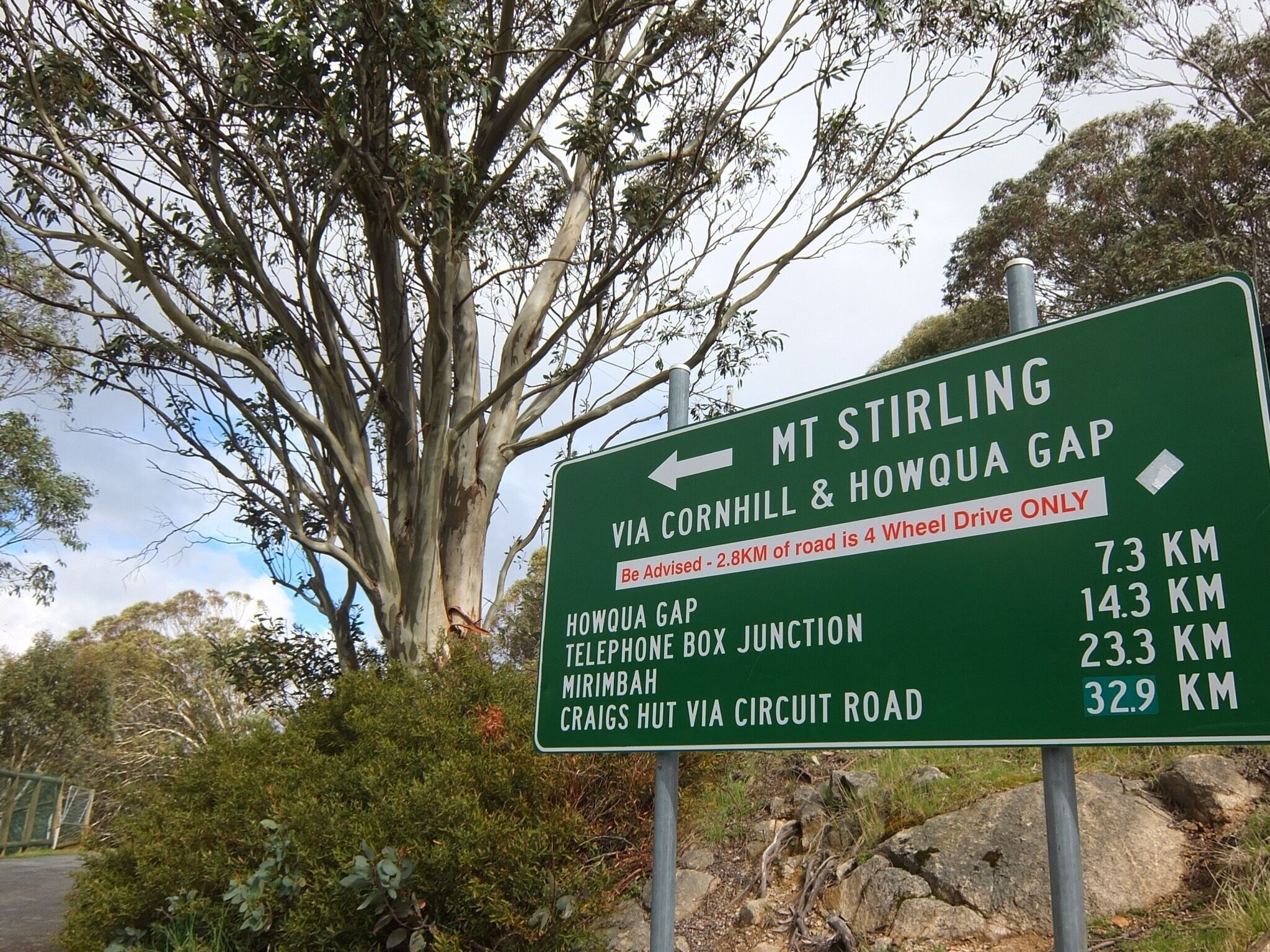 A directional road sign with distances to various locations.