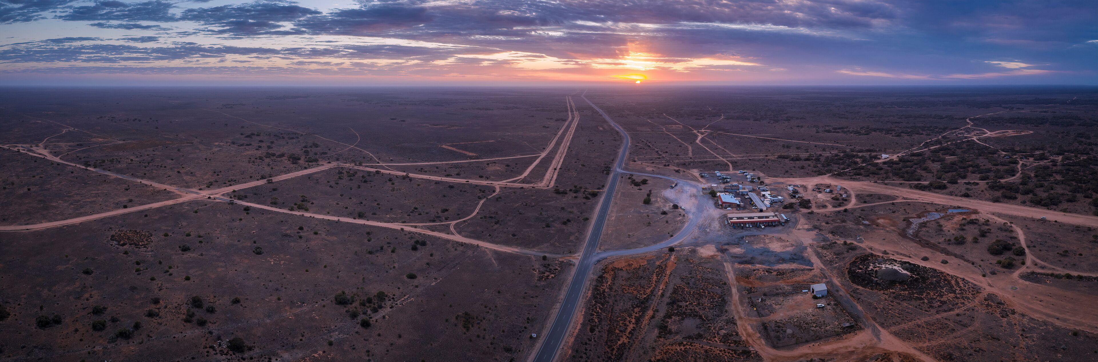 An aerial view of a desert landscape with winding roads and sparse vegetation.