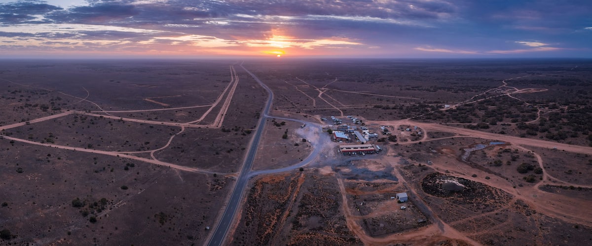 An aerial view of a desert landscape with winding roads and sparse vegetation.
