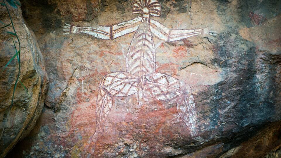 A cave with ancient cave paintings of a human figure.