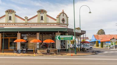Un bâtiment historique doté d’une tour horlogée, d’un café et d’un panneau indiquant la route New England Highway A15.