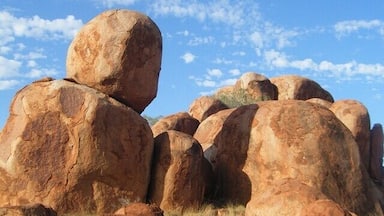 Large boulders in a grassy field under a clear sky.