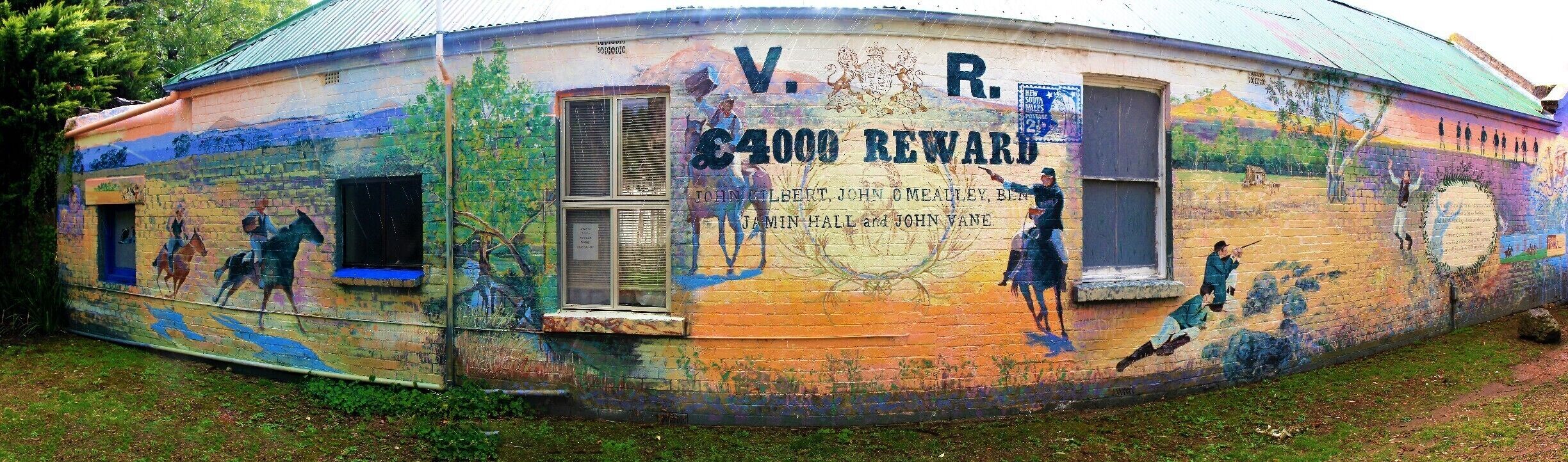 A building with colorful murals and a sign reading "V.R. 4000 REWARD".