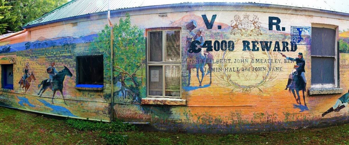 A building with colorful murals and a sign reading "V.R. 4000 REWARD".